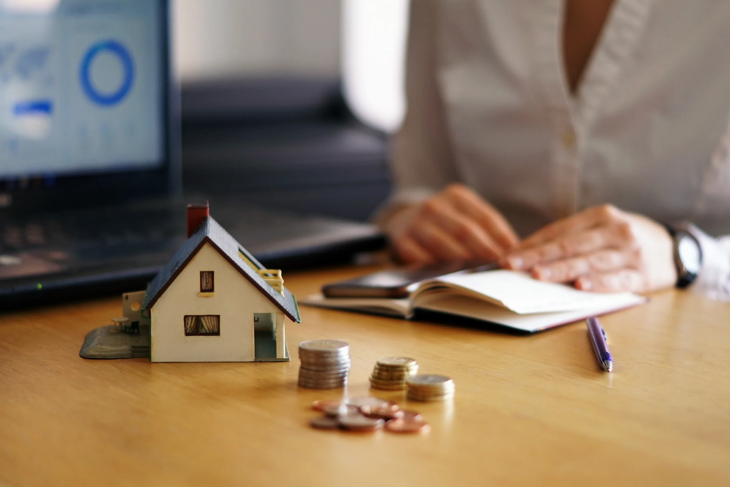 Hands holding a model house representing property investment