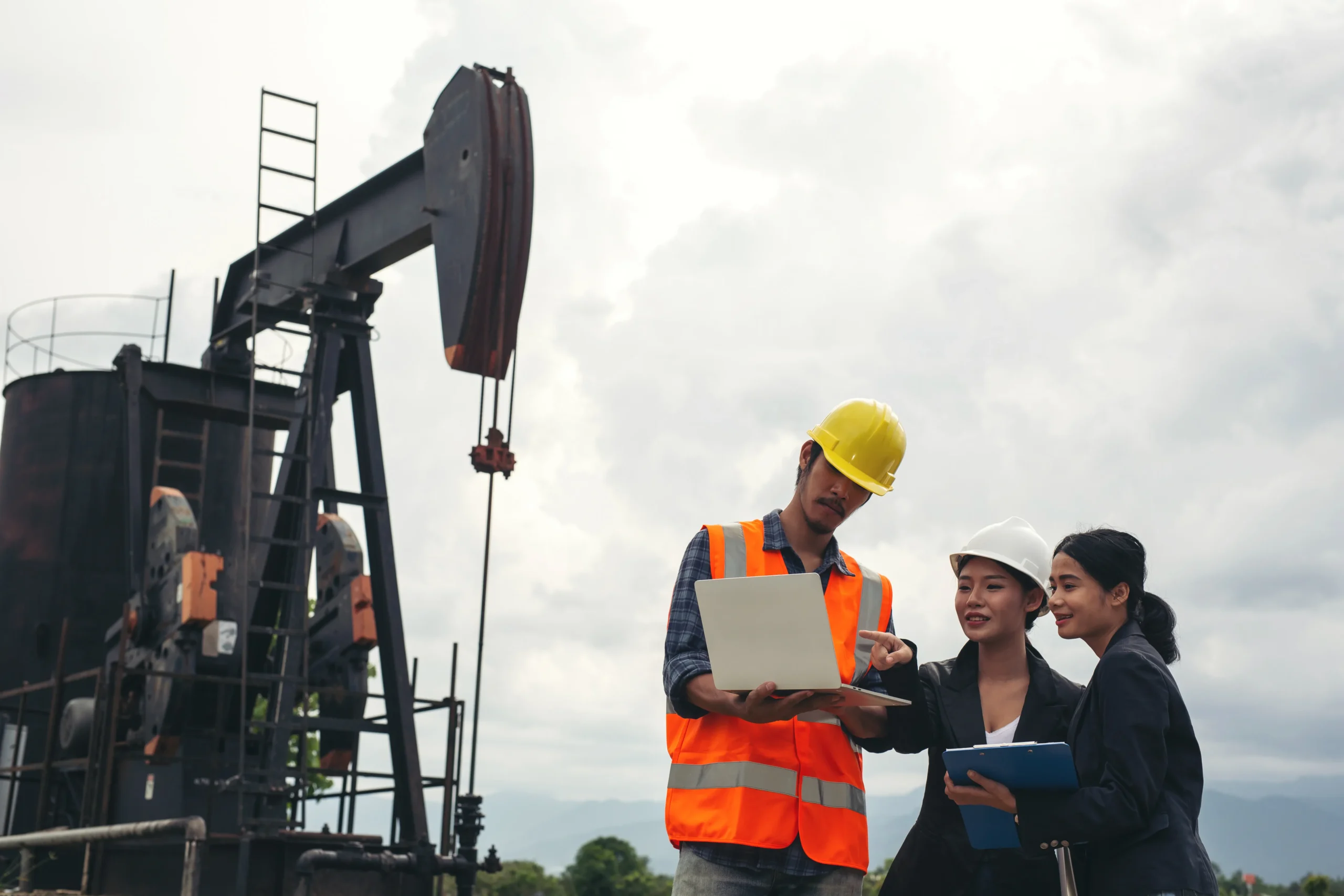 Engineering team beside working oil pumps